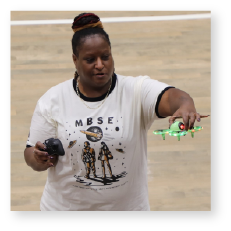 Image of a woman holding a small drone during an AvMC Outreach event